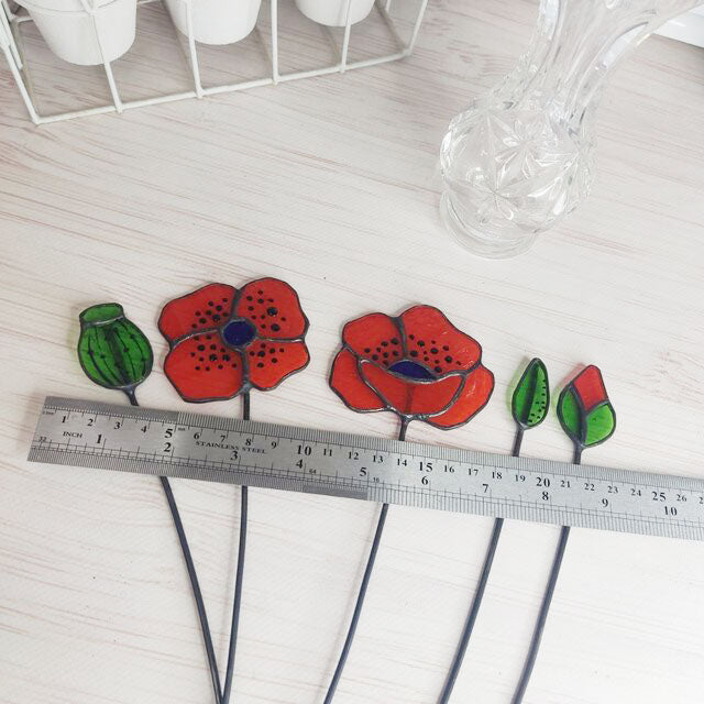 set of flowers and poppy buds made of transparent orange stained glass