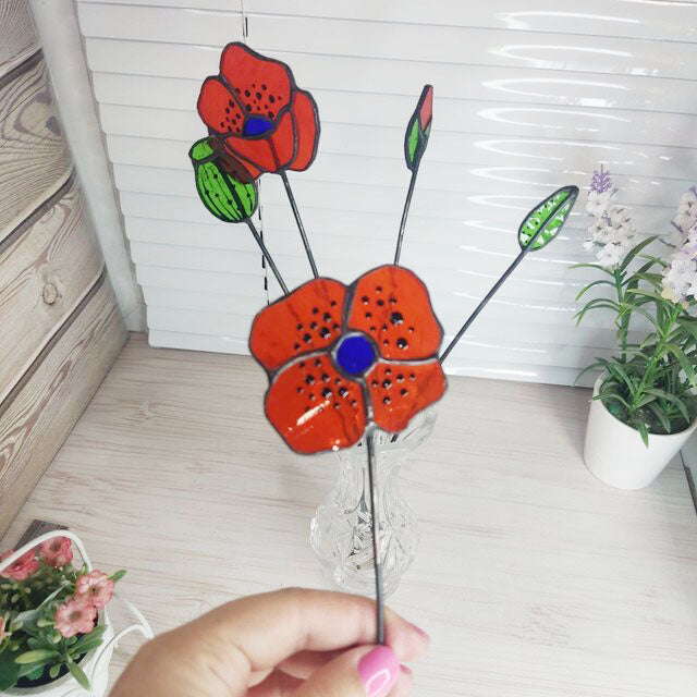 set of flowers and poppy buds made of transparent orange stained glass