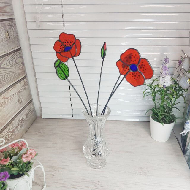 set of flowers and poppy buds made of transparent orange stained glass