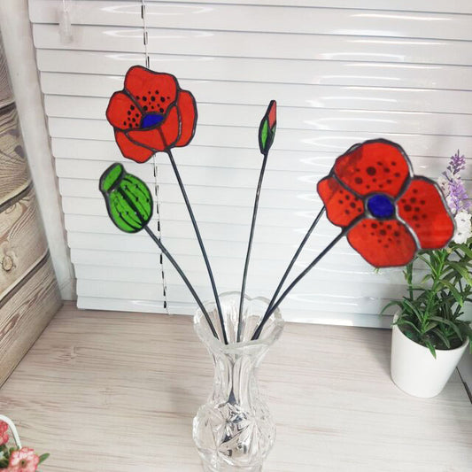 set of flowers and poppy buds made of transparent orange stained glass